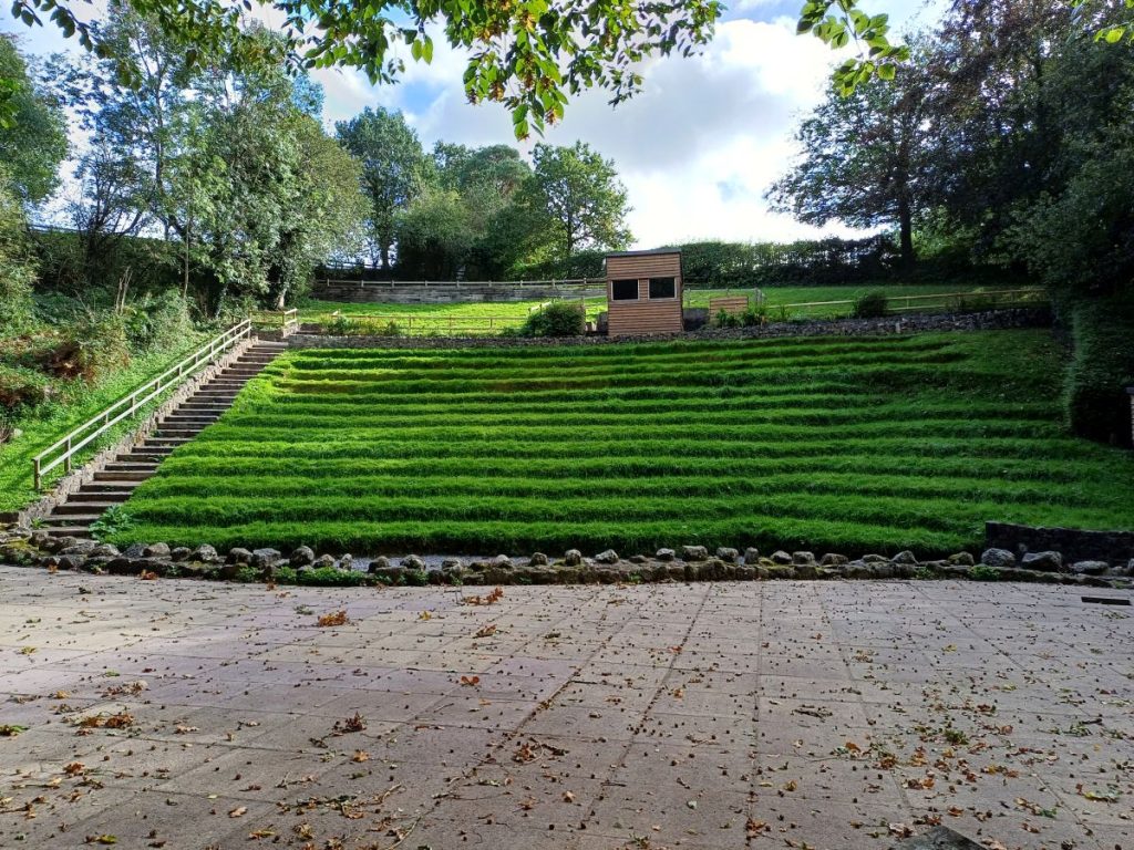 Picture shows an amphitheatre with grassed raked seating area. 
